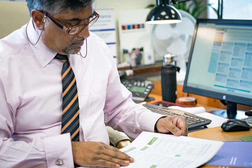 Kamlesh Rajput reviewing client accounts at his desk